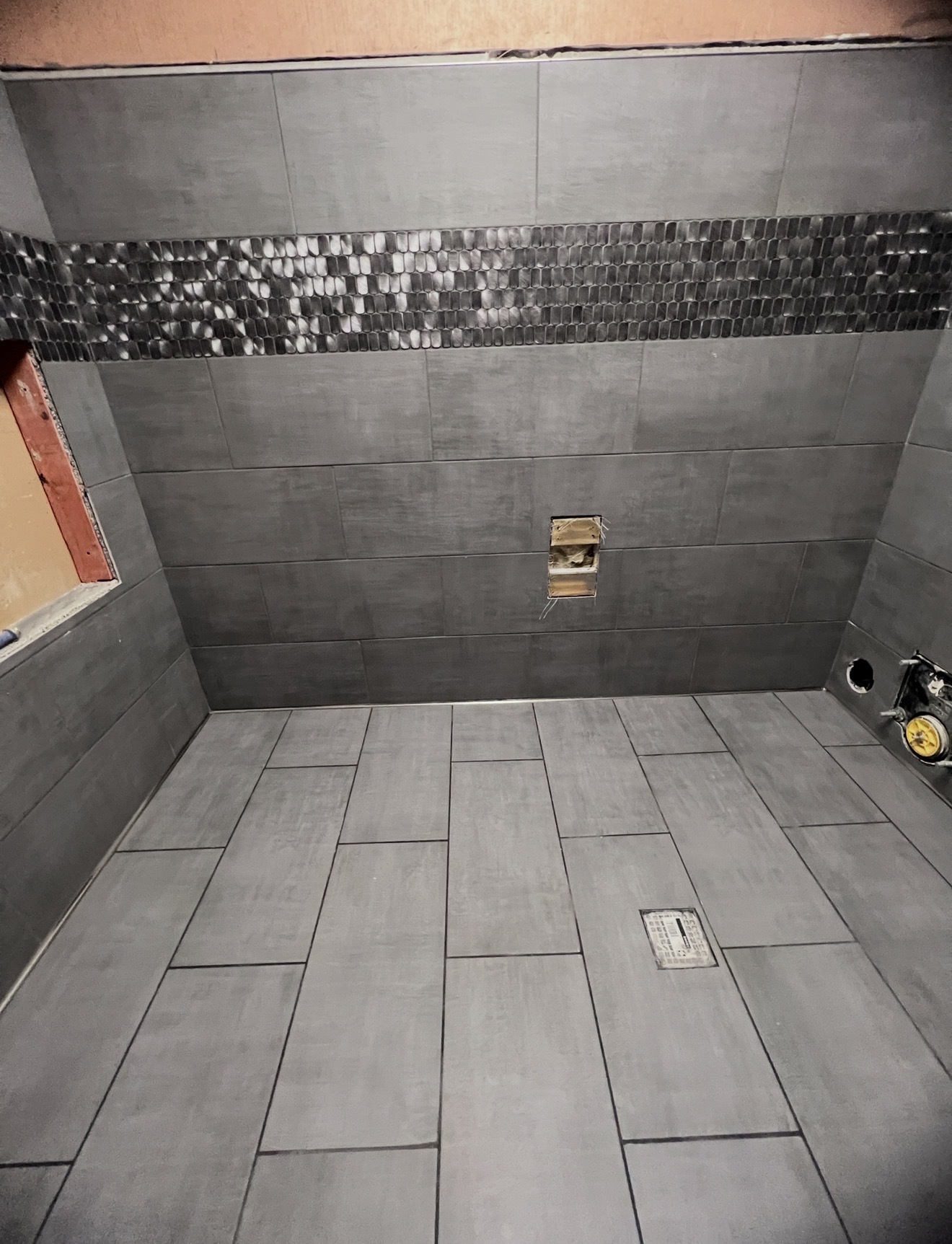 Gray wall and floor tile with a mosaic accent