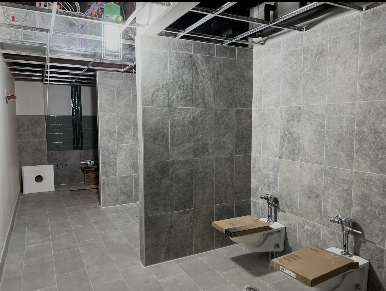 Large-format wall and floor tile in a commercial restroom